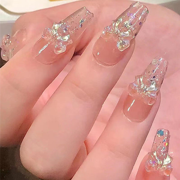 Artificial nails with heart design and glitter accents 
Maetiva
