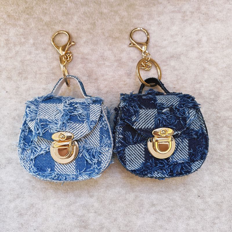 Distressed denim micro crossbody mini purse with gold turn-lock top handle 
Maetiva
