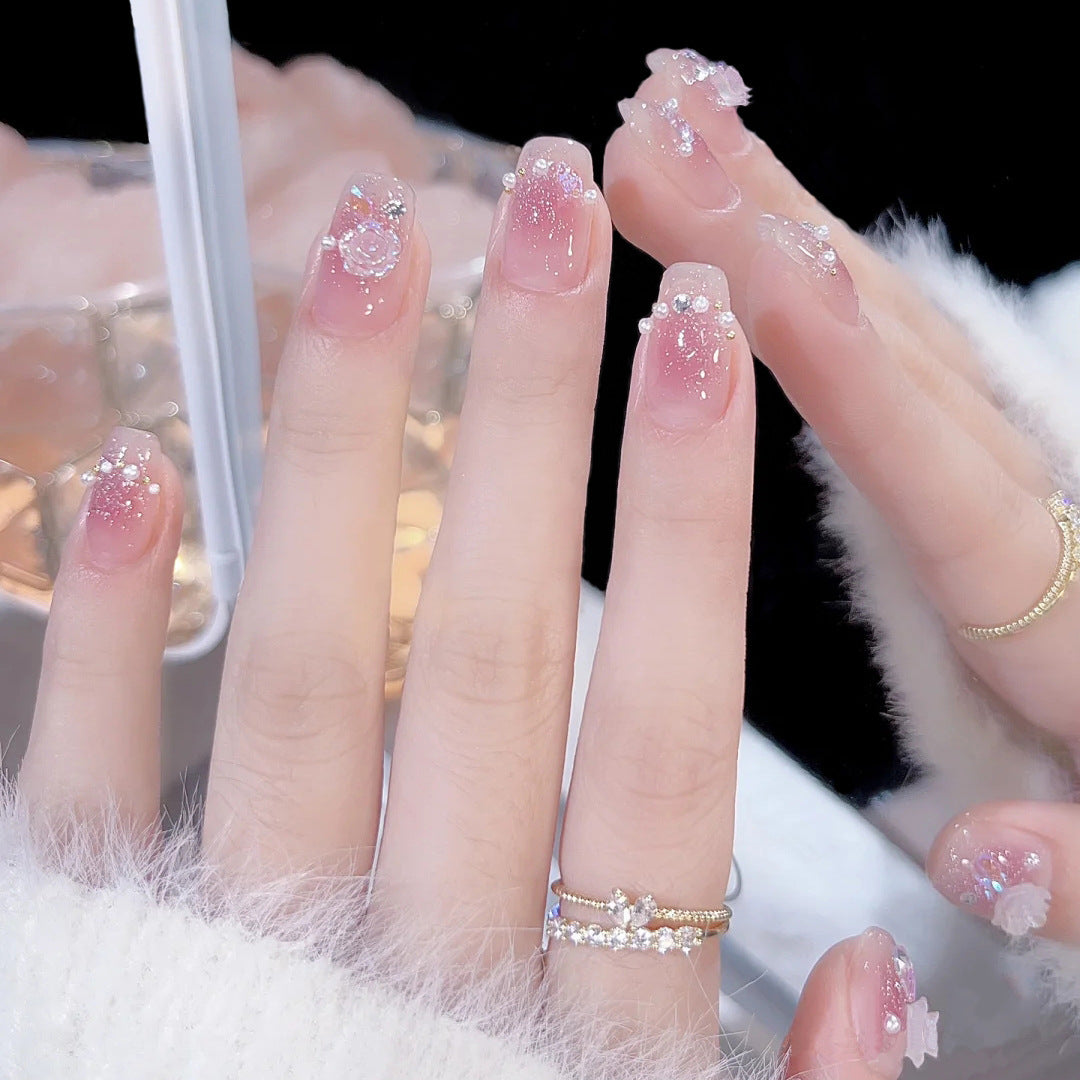 Artificial nails with heart design and glitter accents 
Maetiva