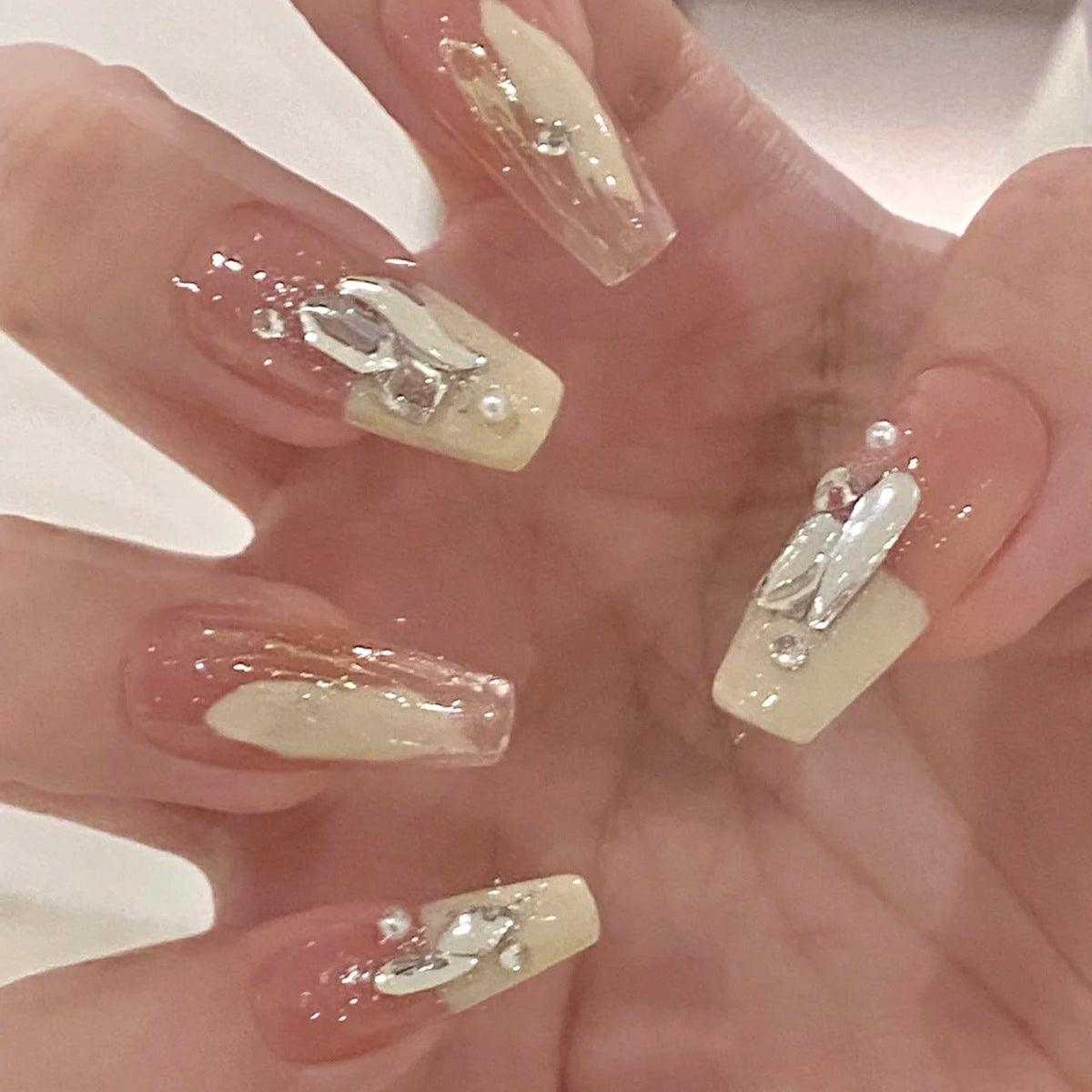 Artificial nails with heart design and glitter accents 
Maetiva