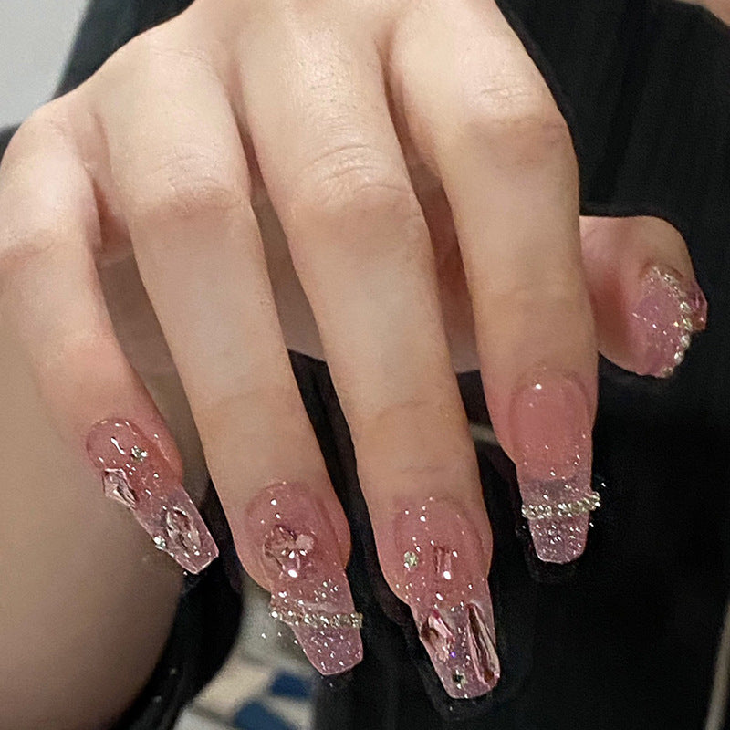 Artificial nails with heart design and glitter accents 
Maetiva