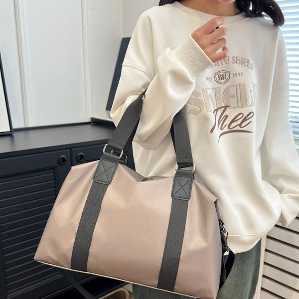 Athletic travel bag made of weather-resistant material with adjustable carrying handles 
Maetiva
