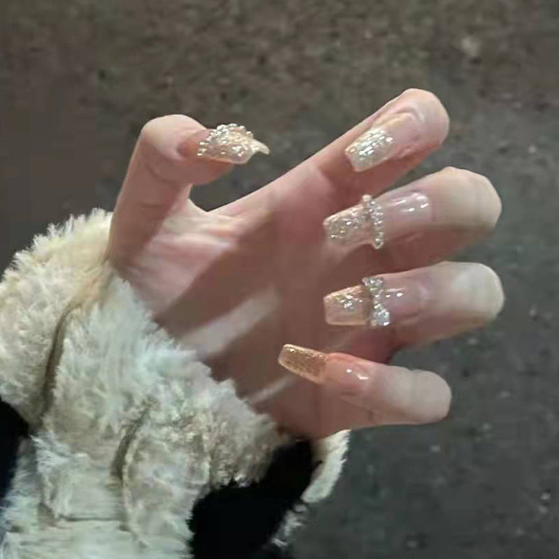 Artificial nails with heart design and glitter accents 
Maetiva