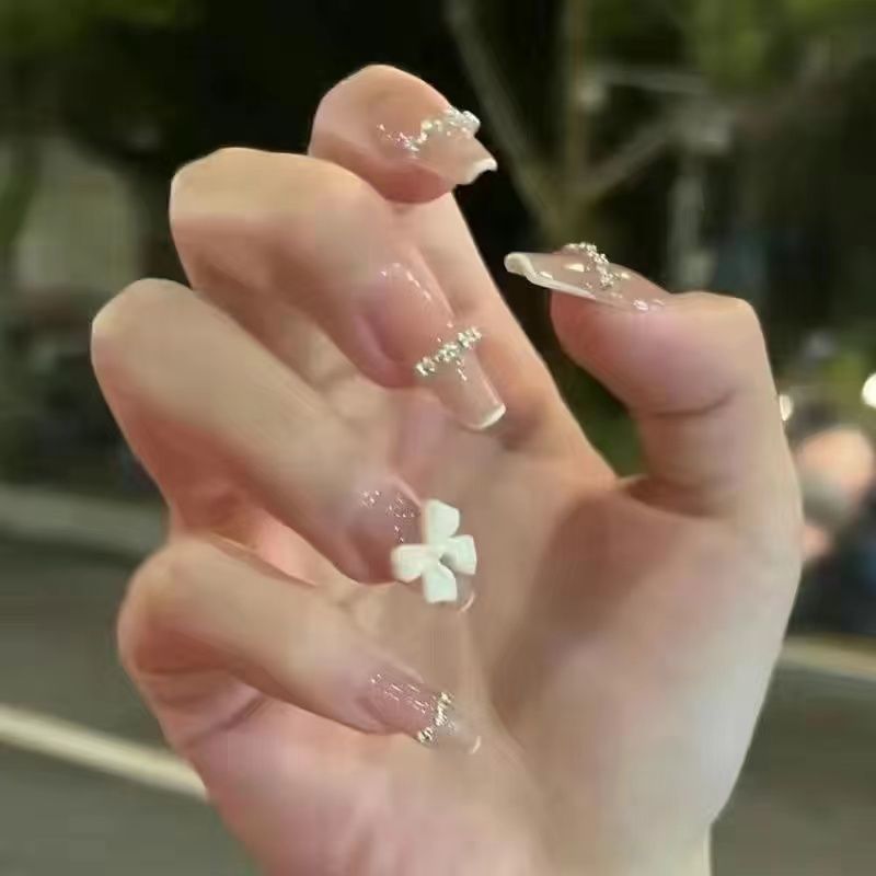 Artificial nails with heart design and glitter accents 
Maetiva