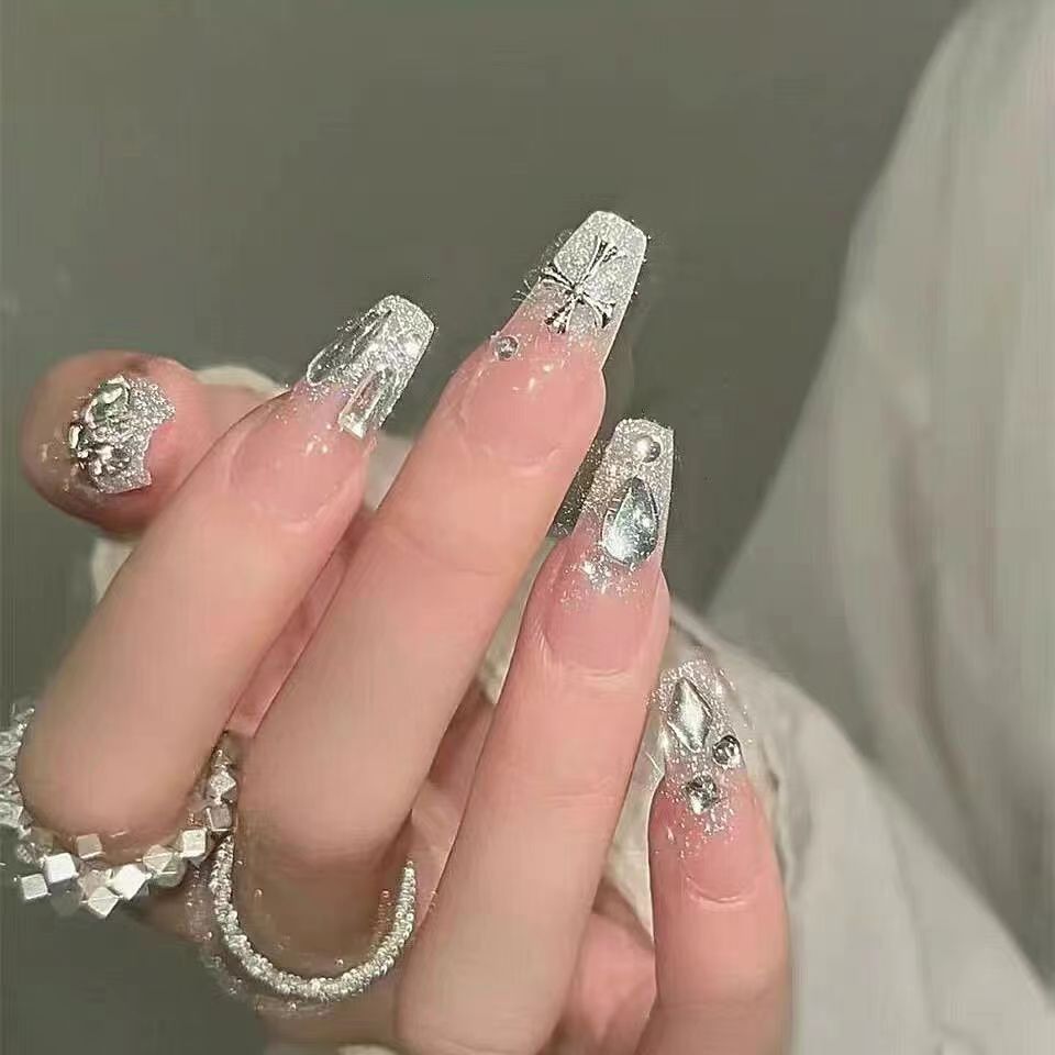 Artificial nails with heart design and glitter accents 
Maetiva