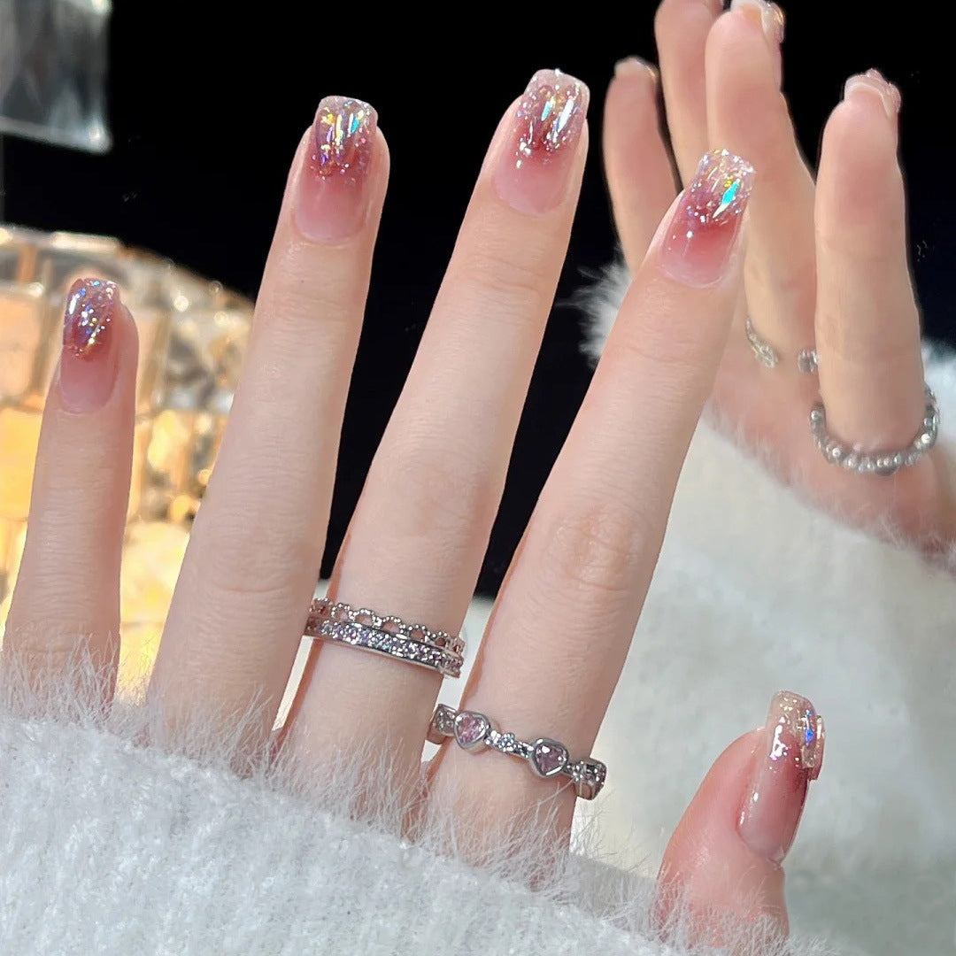 Artificial nails with heart design and glitter accents 
Maetiva
