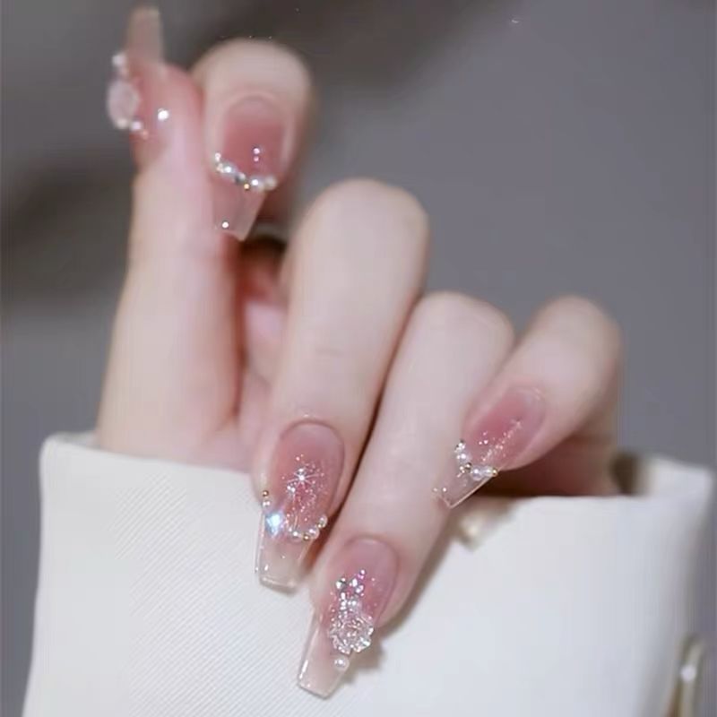 Artificial nails with heart design and glitter accents 
Maetiva