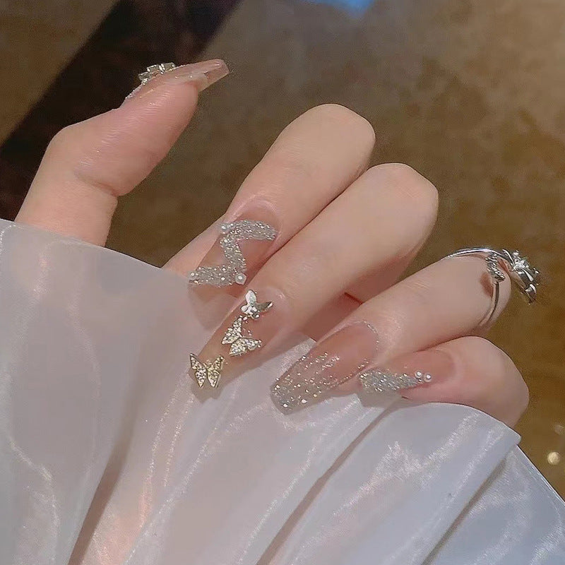 Artificial nails with heart design and glitter accents 
Maetiva
