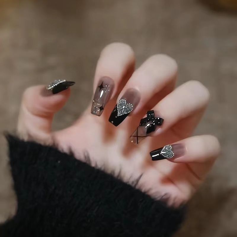 Artificial nails with heart design and glitter accents 
Maetiva