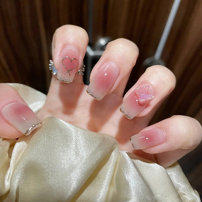 Artificial nails with heart design and glitter accents 
Maetiva