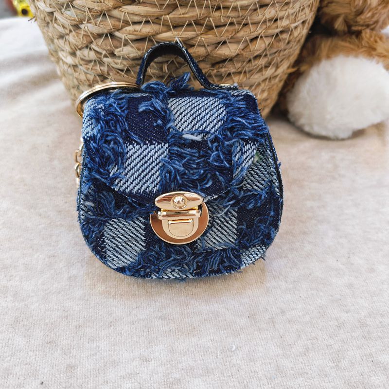 Distressed denim micro crossbody mini purse with gold turn-lock top handle 
Maetiva