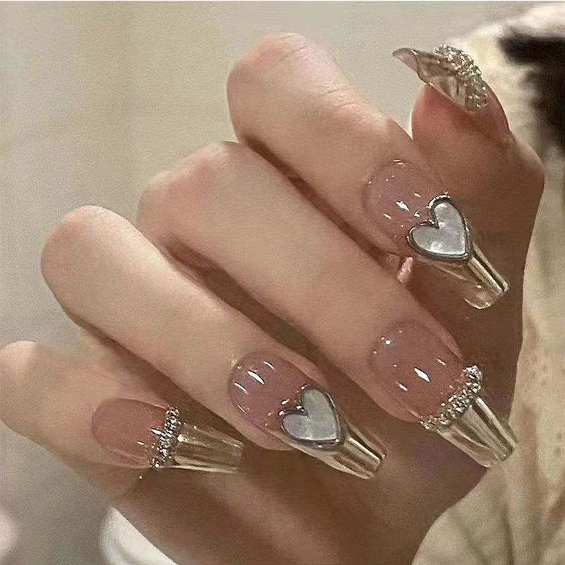 Artificial nails with heart design and glitter accents 
Maetiva