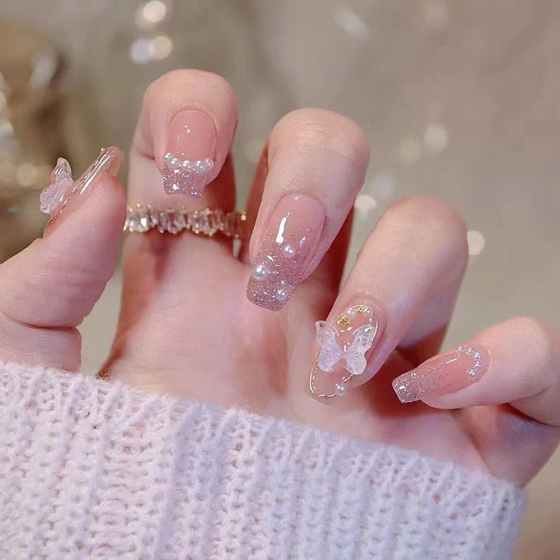 Artificial nails with heart design and glitter accents 
Maetiva