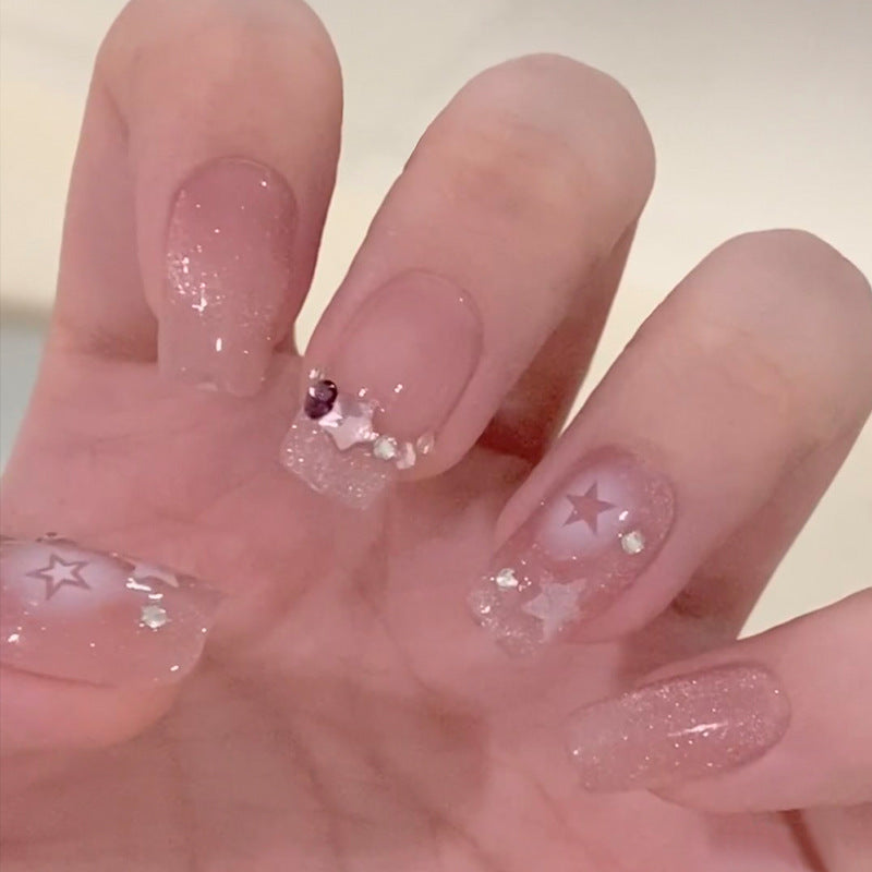 Artificial nails with heart design and glitter accents 
Maetiva