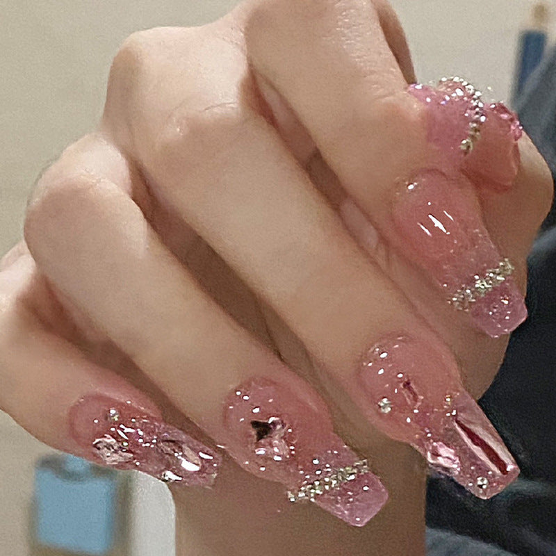 Artificial nails with heart design and glitter accents 
Maetiva