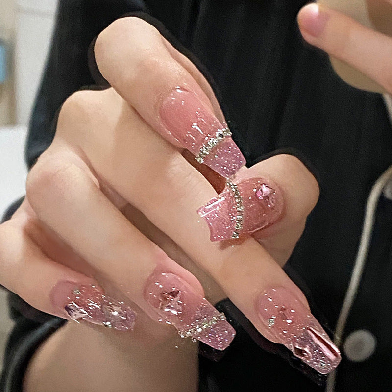 Artificial nails with heart design and glitter accents 
Maetiva