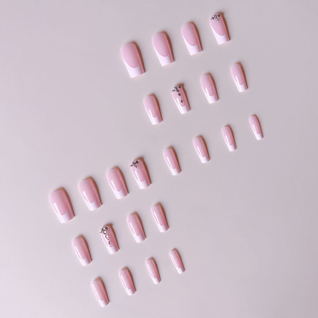 Acrylic nail set with elegant French tips and sparkling rhinestone accents 
Maetiva