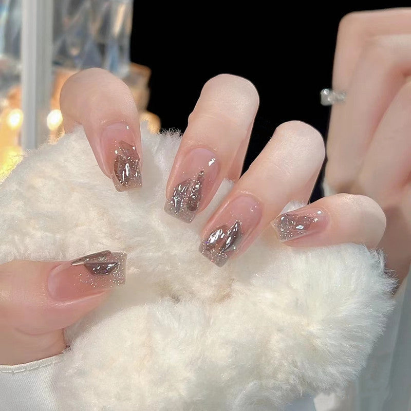 Artificial nails with heart design and glitter accents 
Maetiva