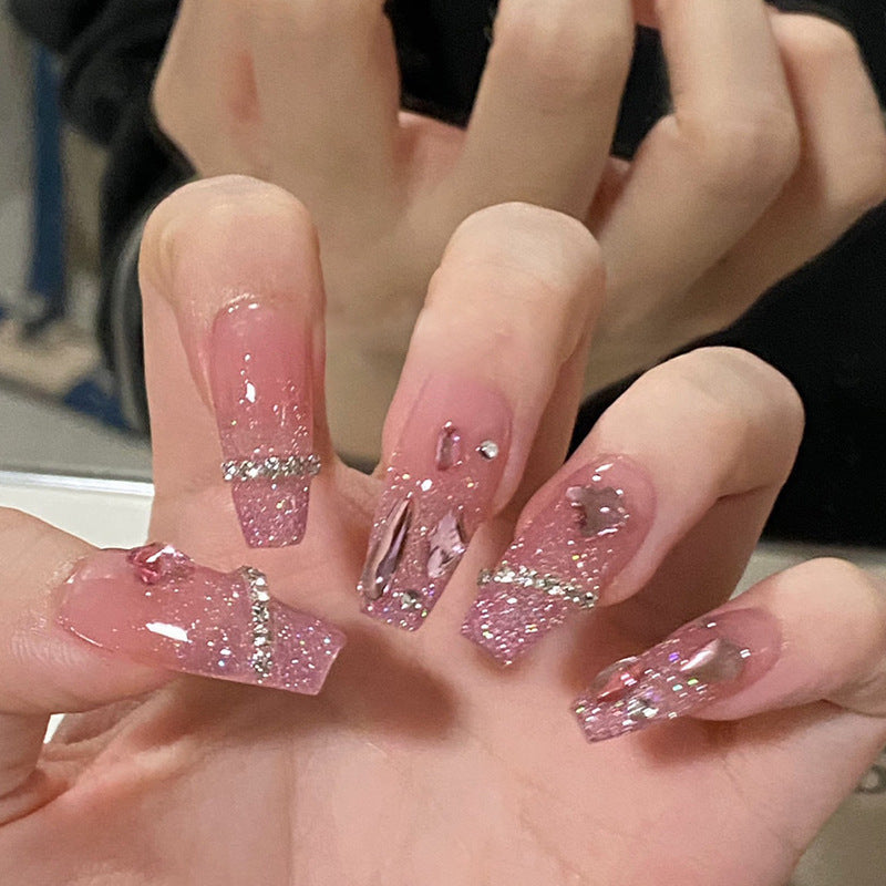 Artificial nails with heart design and glitter accents 
Maetiva