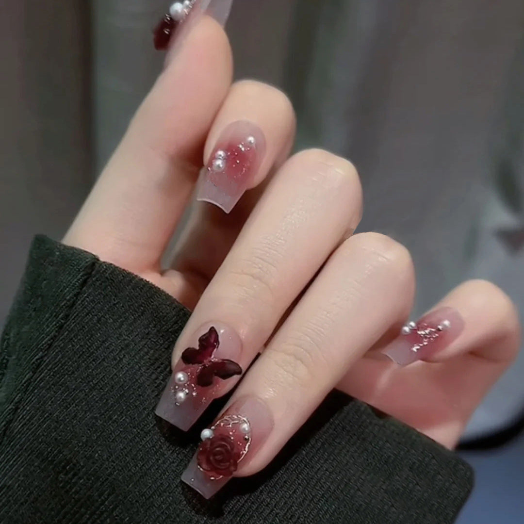 Artificial nails with heart design and glitter accents 
Maetiva
