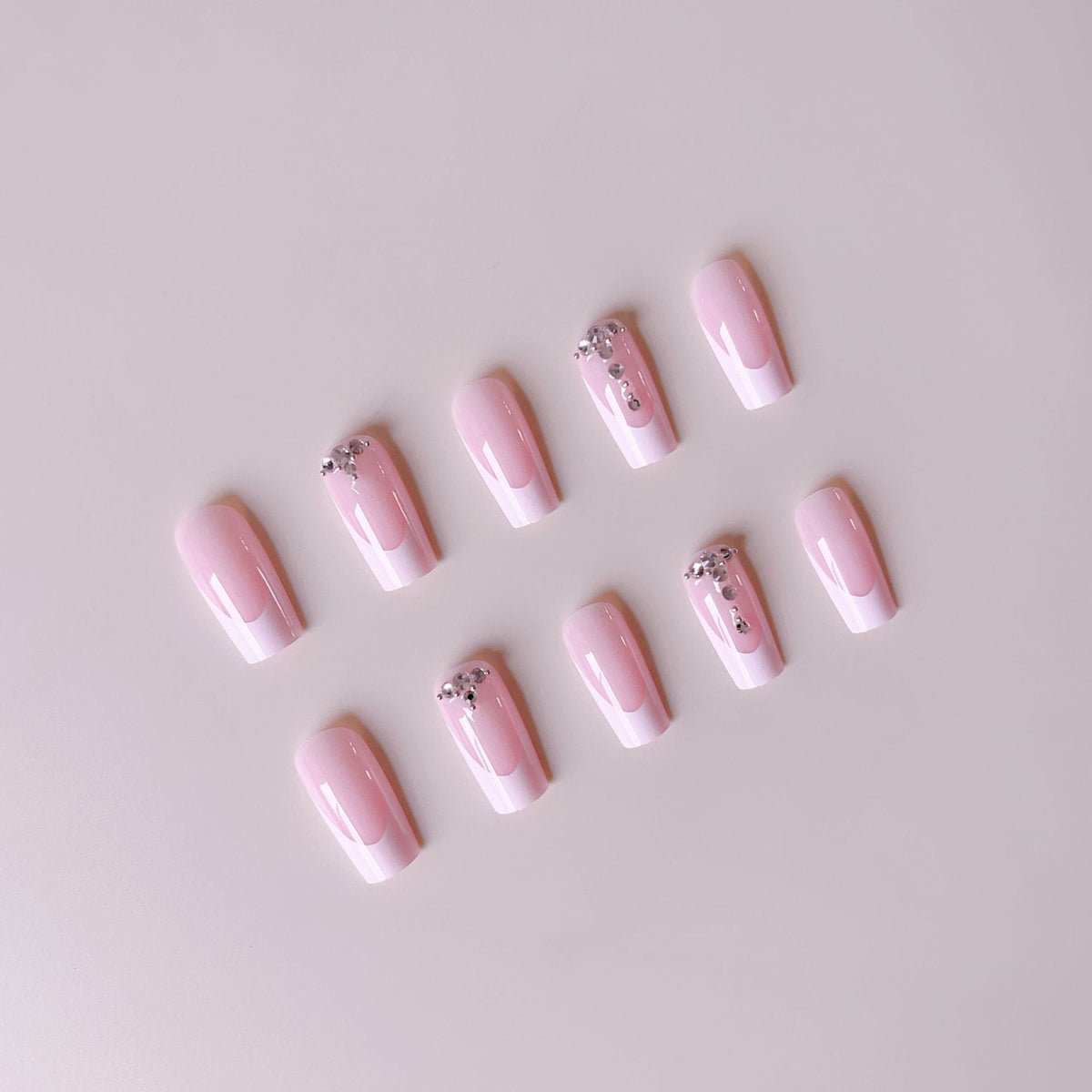Acrylic nail set with elegant French tips and sparkling rhinestone accents 
Maetiva
