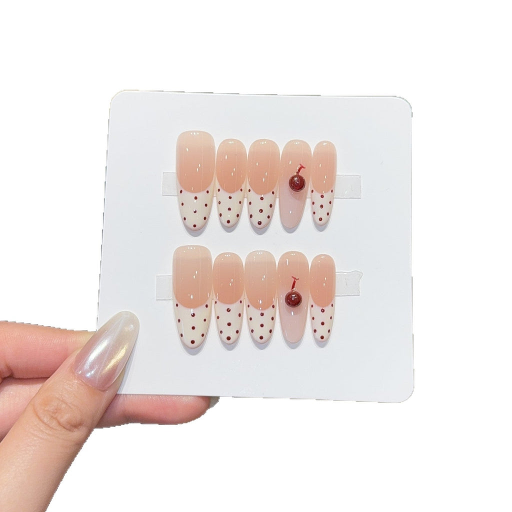 Artificial nails with playful design and cherry accents 
Maetiva