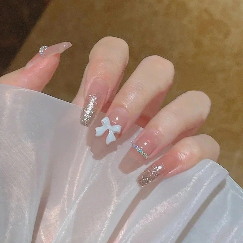 Artificial nails with heart design and glitter accents 
Maetiva