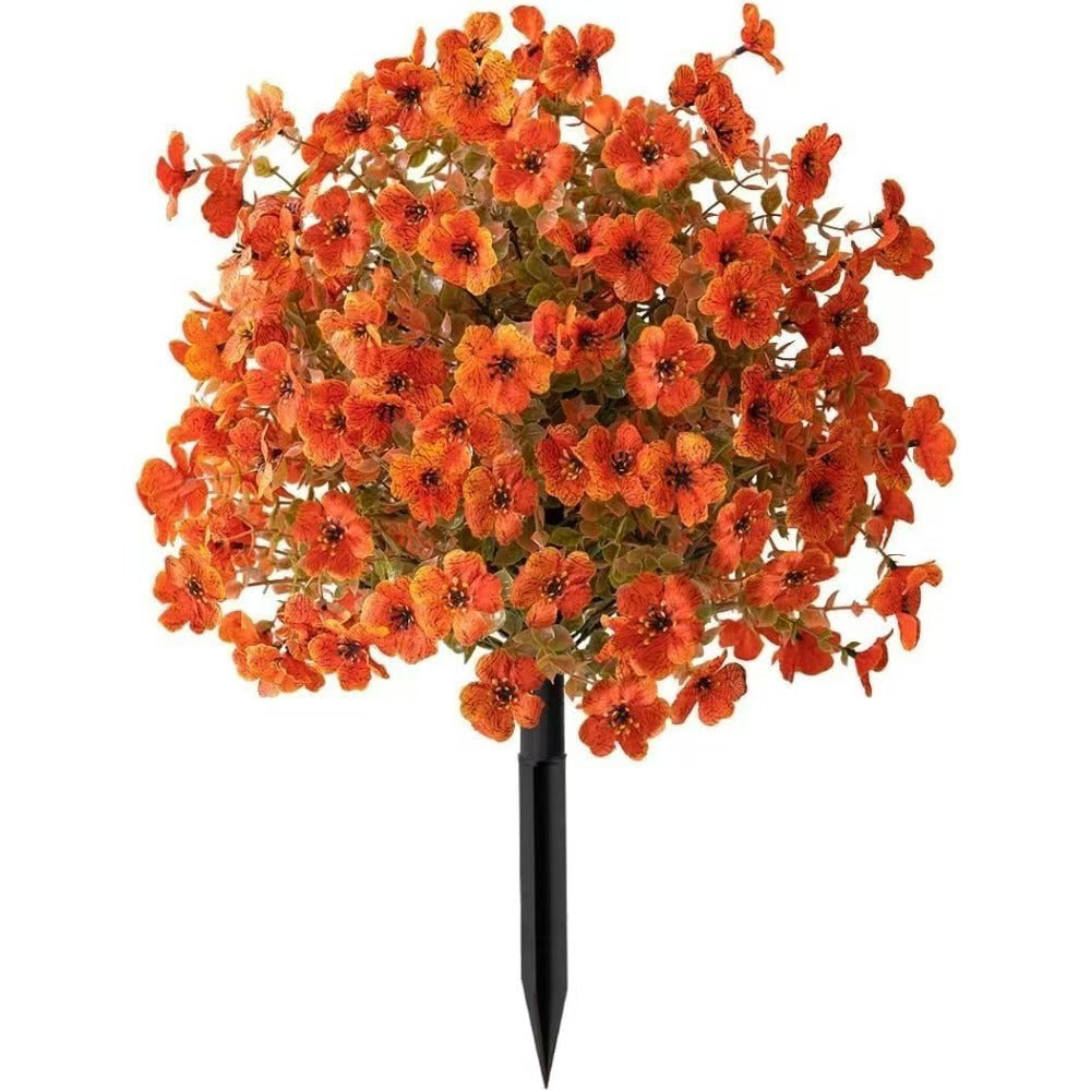 Orange artificial flower stake with dense blooms, green leaves and black ground stake